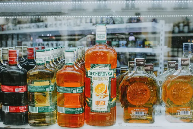 An array of vibrant liquor bottles displayed in a store showcase highlighting various spirits.